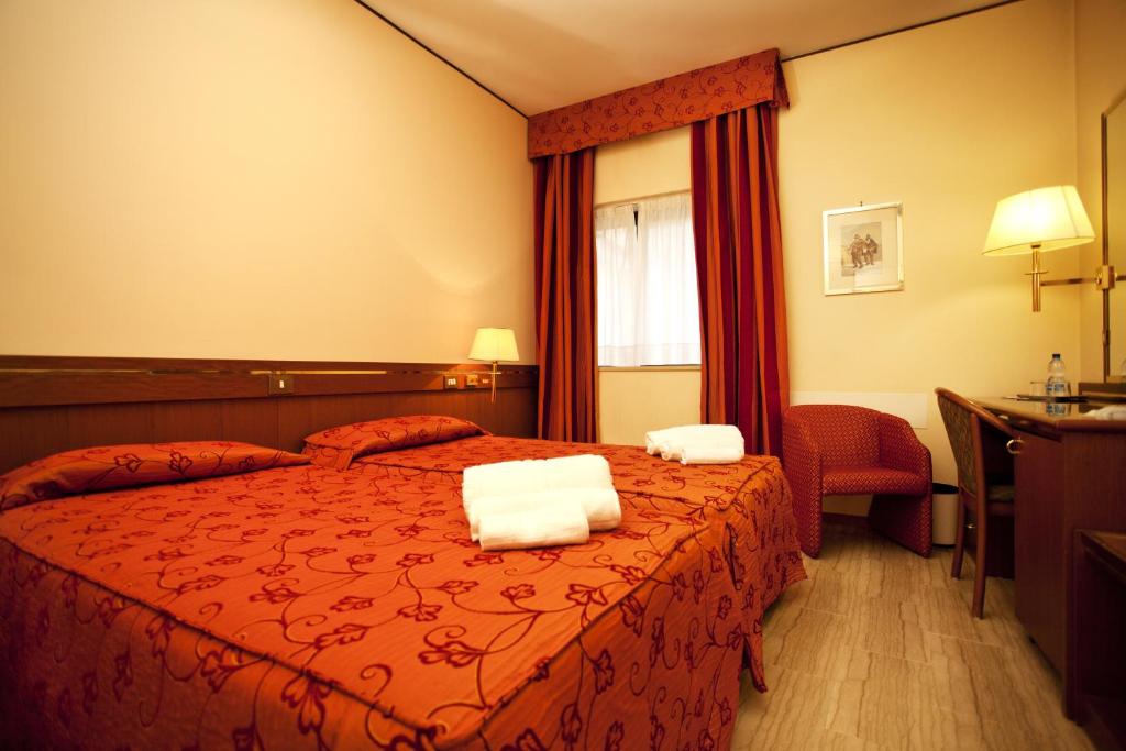 a hotel room with a bed with two towels on it at Augustus in Ottaviano