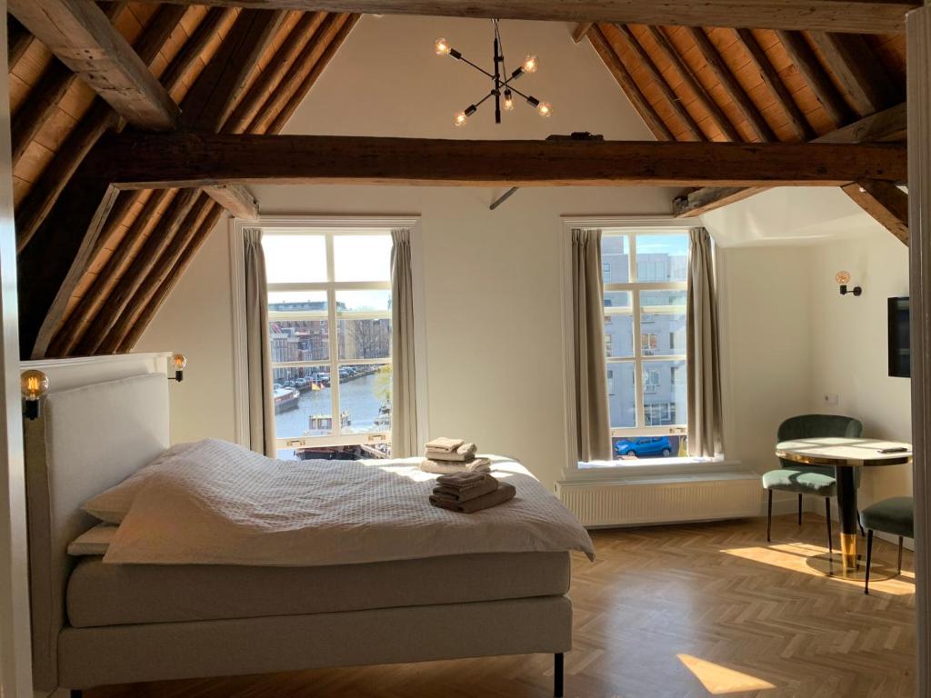 sypialnia z łóżkiem i dużym oknem w obiekcie The Harbour Leiden w Lejdzie