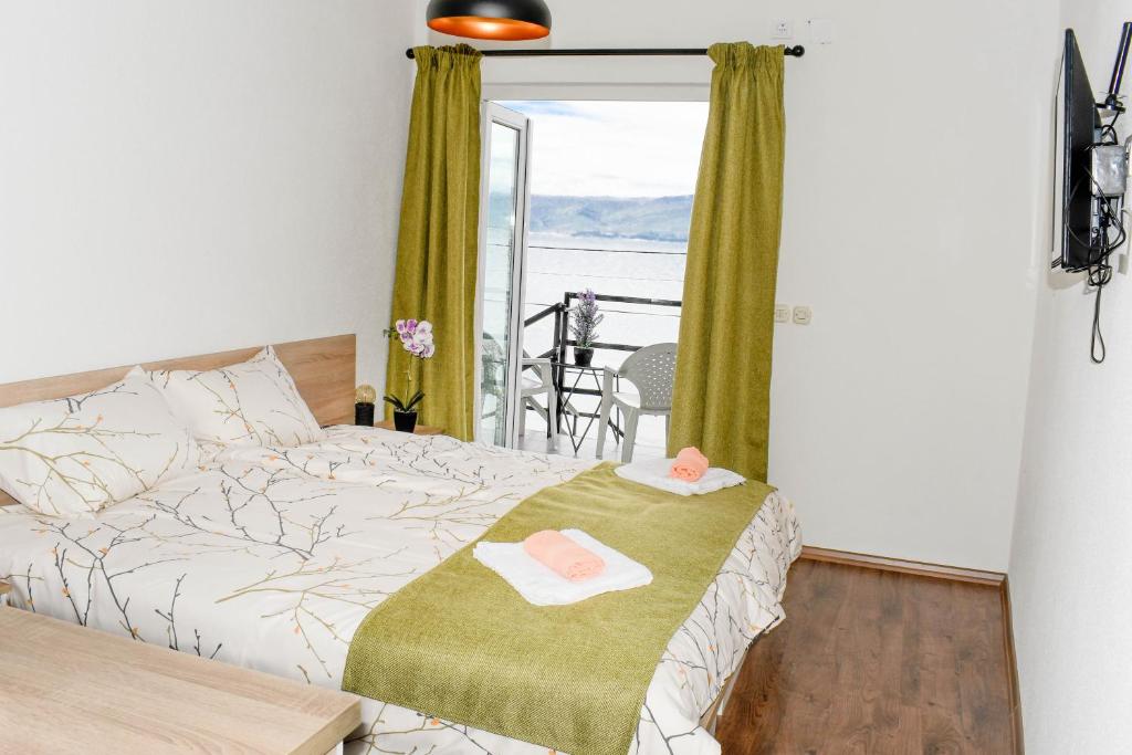a bedroom with a bed and a balcony with a view at KLIO Apartments in Struga
