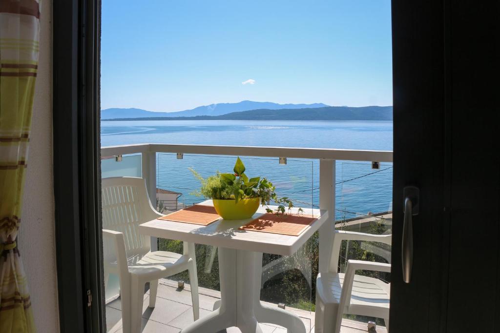 a table and chairs on a balcony with a view of the ocean at Villa Riki in Živogošće