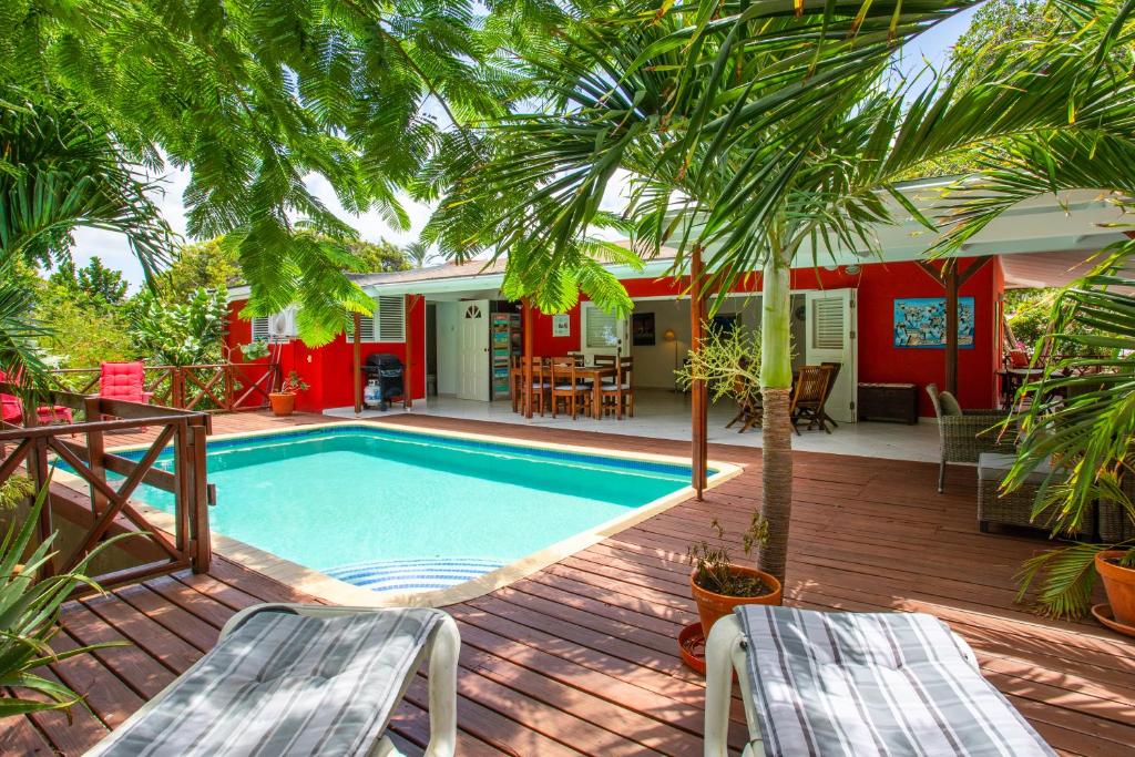 - une piscine avec 2 chaises et une maison dans l'établissement Piscadera Bay bungalow Kolibri, à Willemstad