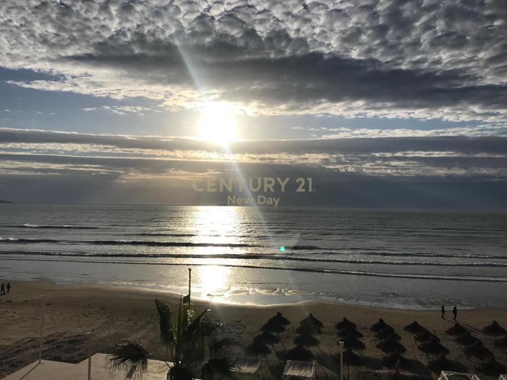 a view of the ocean with the sun setting on the beach at Sea View Apartment in Durrës