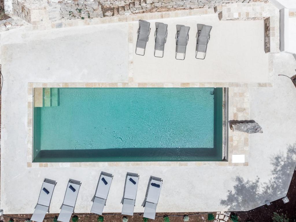 an overhead view of a swimming pool with chairs around it at Il Sassofono in Cisternino