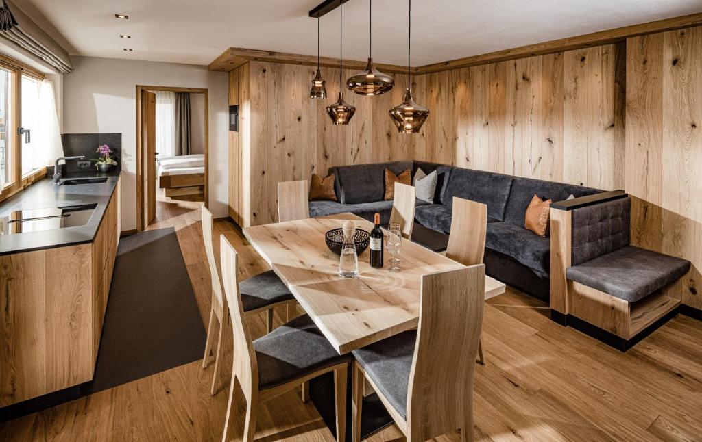 uma sala de jantar com uma mesa e um sofá em Apartments Belaval em Santa Cristina in Val Gardena