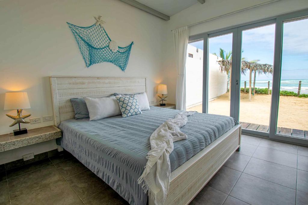 a bedroom with a bed with a view of the beach at Sandy Feet House in Puerto Villamil