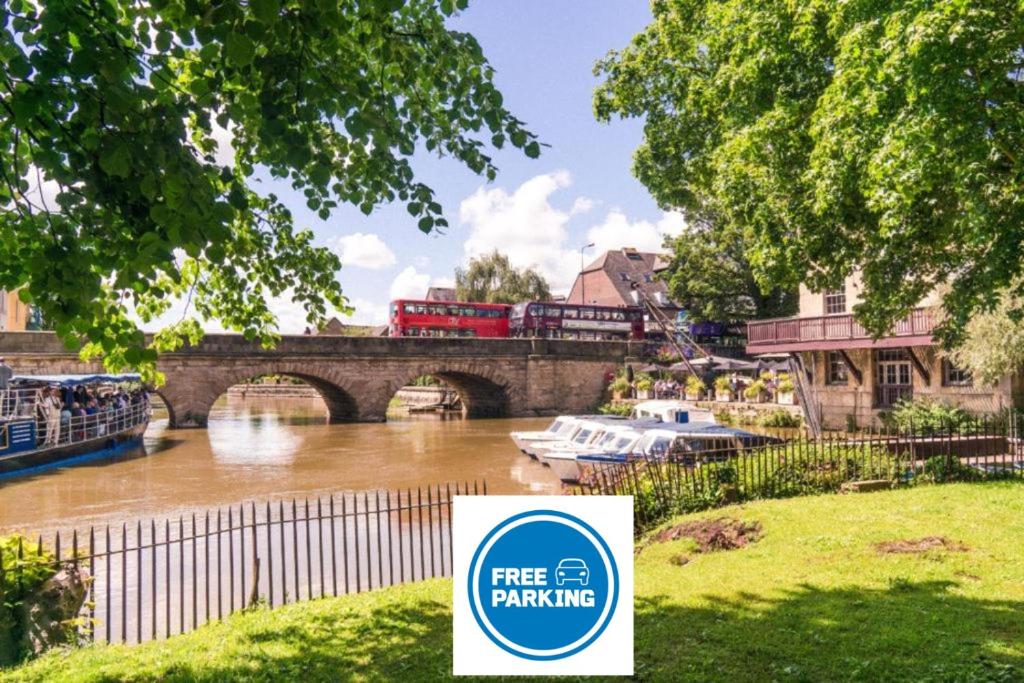 a train crossing a bridge over a river with a sign at La casetta d'Àneu in Oxford