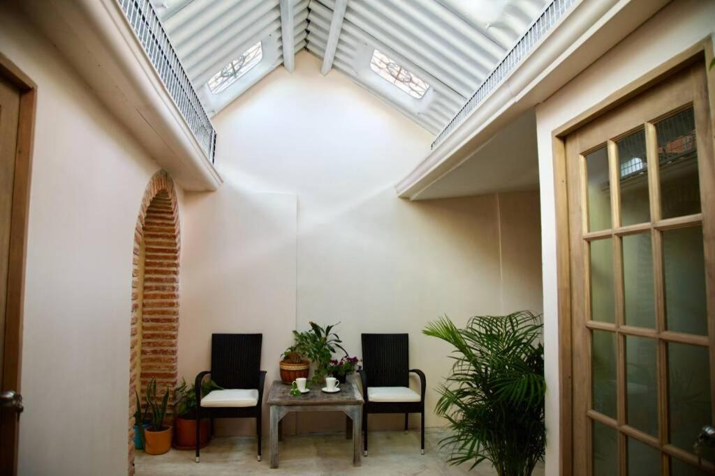 卡塔赫納的住宿－GREAT LOCATION ! 4 Bedroom Home in the Heart of Cartagena，配有桌椅和天花板的客房