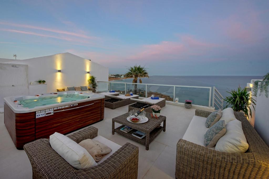 un salon avec un bain à remous sur un balcon dans l'établissement Casa Latino - Oceanfront - Luxury & Charming villa- Jacuzzi at Rooftop, à Albufeira