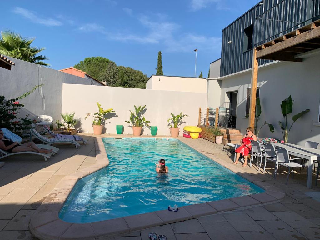 une personne se baignant dans une piscine dans l'établissement Duplex indépendant avec accès piscine, à Vendargues