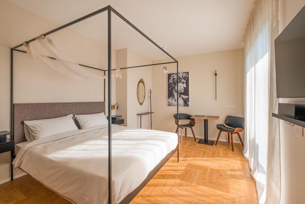 a bedroom with a large bed and a table at Plaza Lago di Garda in Peschiera del Garda