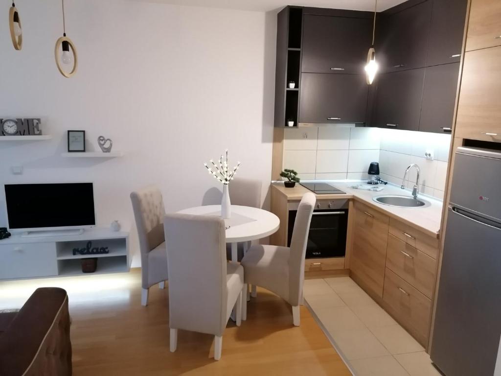 een keuken met een witte tafel en stoelen bij Emili Apartman in Jagodina