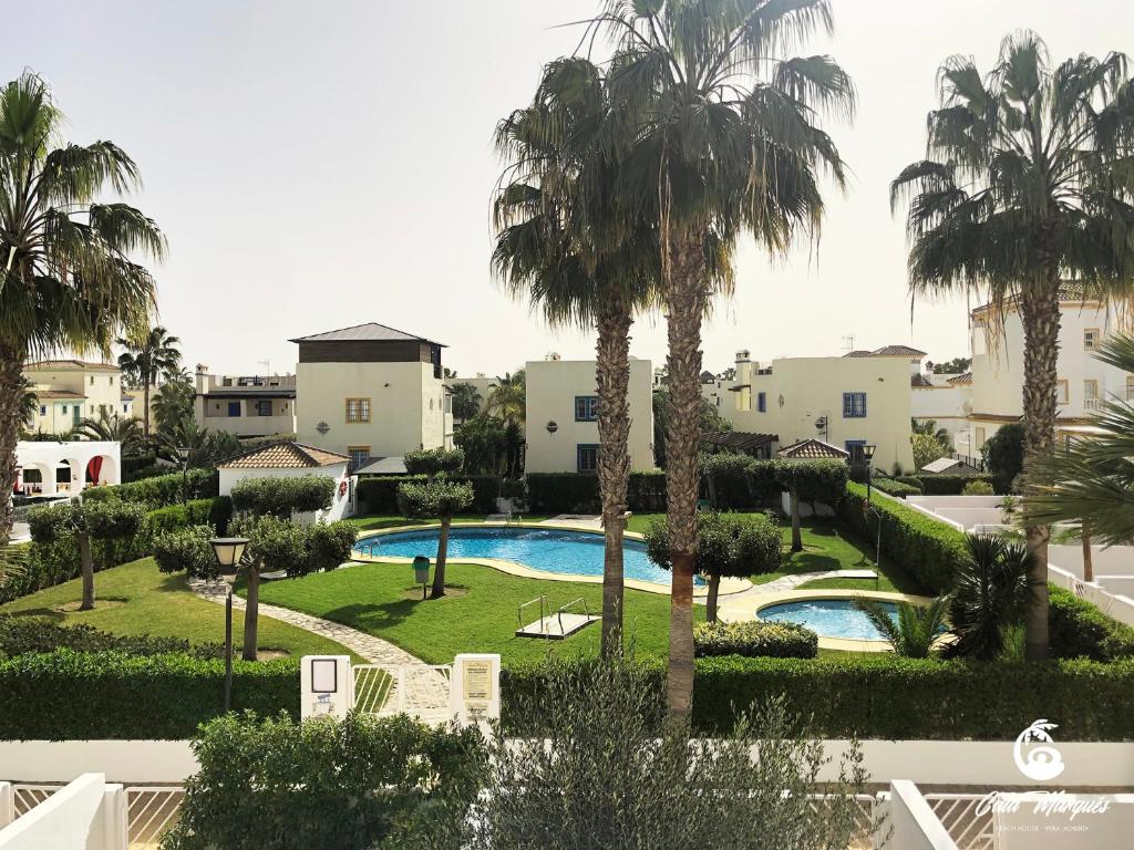 維拉的住宿－Cala Marqués Beach House，享有带游泳池和棕榈树的度假村的景致