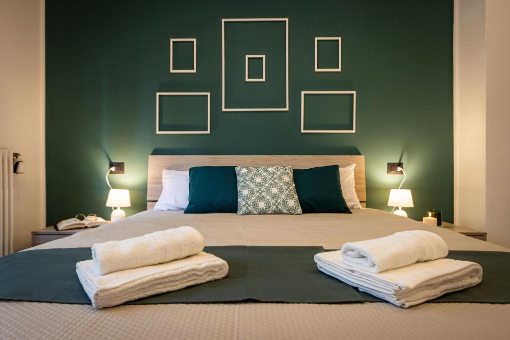 una camera da letto con un grande letto con una parete verde di Green Pearl ✰✰✰✰✰ Appartamento a 100 metri dal lago ad Arona