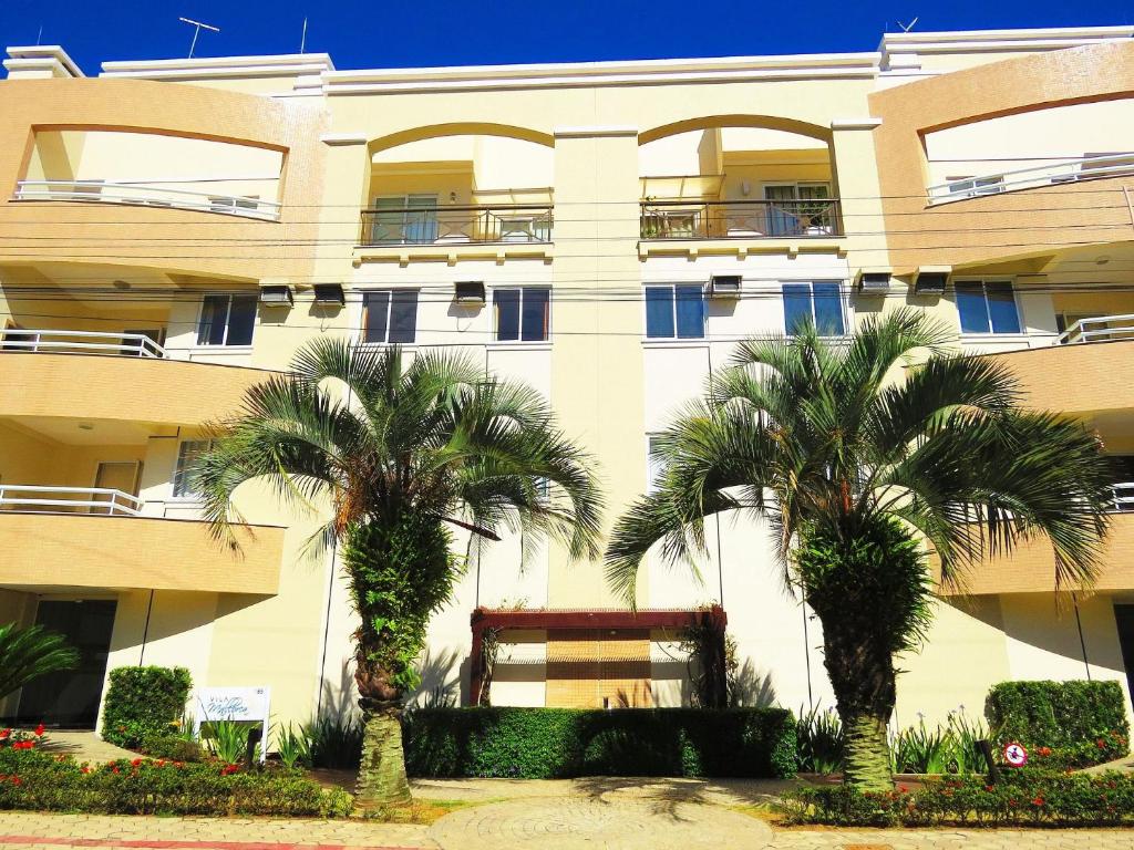 un edificio con palmeras delante en Ed. Vila Malorca, en Bombinhas