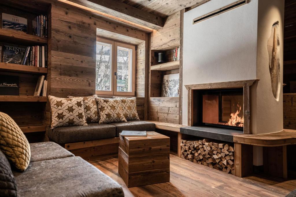 sala de estar con sofá y chimenea en ALPINE DAYS Mountain Home, en Madonna di Campiglio