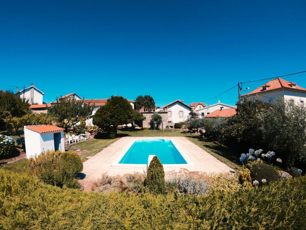a villa with a swimming pool in a garden at Villa Oliveira in Melo