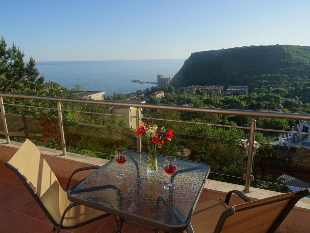 a table with two glasses of wine on a balcony at Complex Karia I in Kavarna
