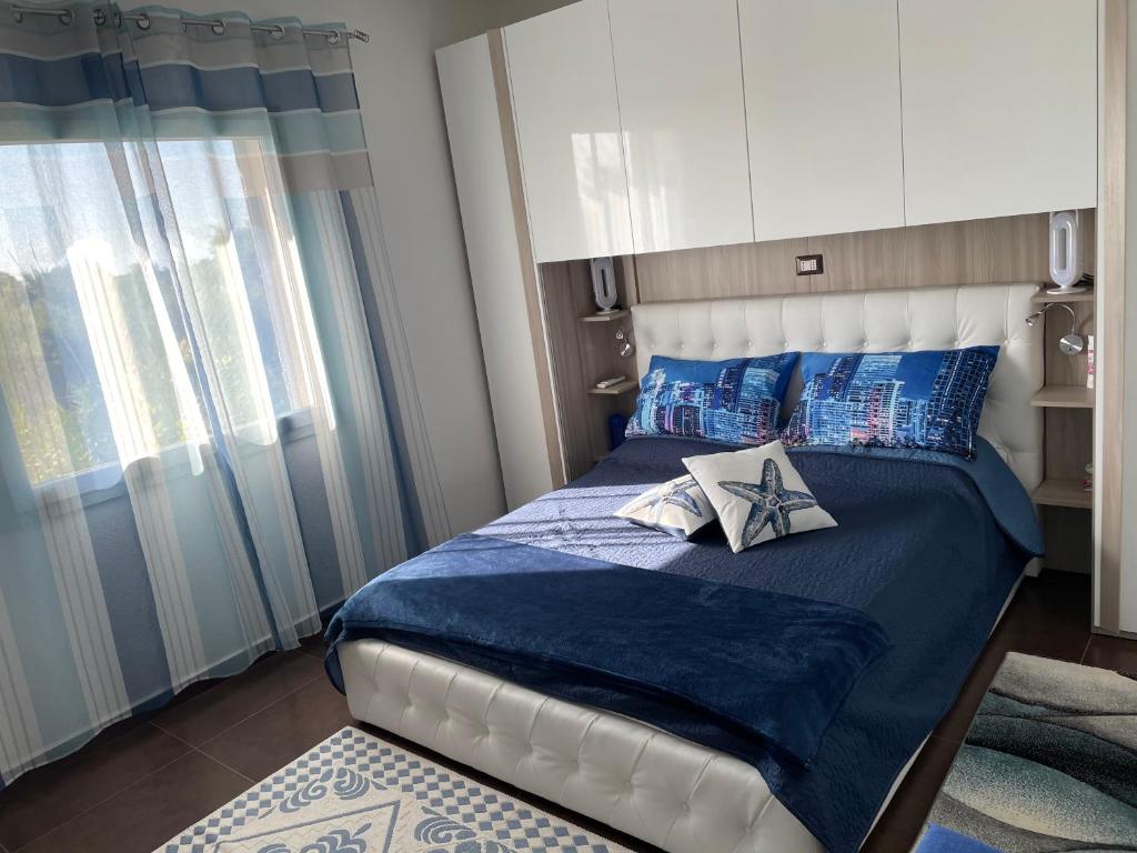 - une chambre avec un lit doté de draps bleus et d'oreillers bleus dans l'établissement Blue Sardinia Tourism, à Budoni