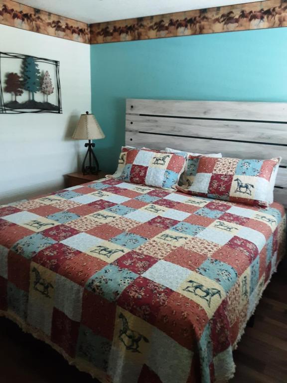 um quarto com uma cama com uma colcha em Horseshoe Riverside Lodge em Canyon Lake