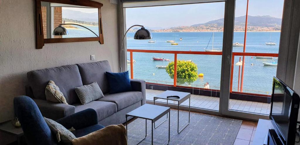 a living room with a couch and a view of the water at Vista Azul in Baiona