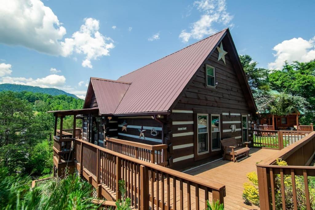 a large wooden cabin with a deck and a roof at Bear Claw Cove - hot tub, jacuzzi, fireplace, view in Sevierville