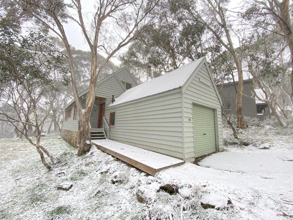 una pequeña casa con un porche en la nieve en Tabletop Down, en Dinner Plain