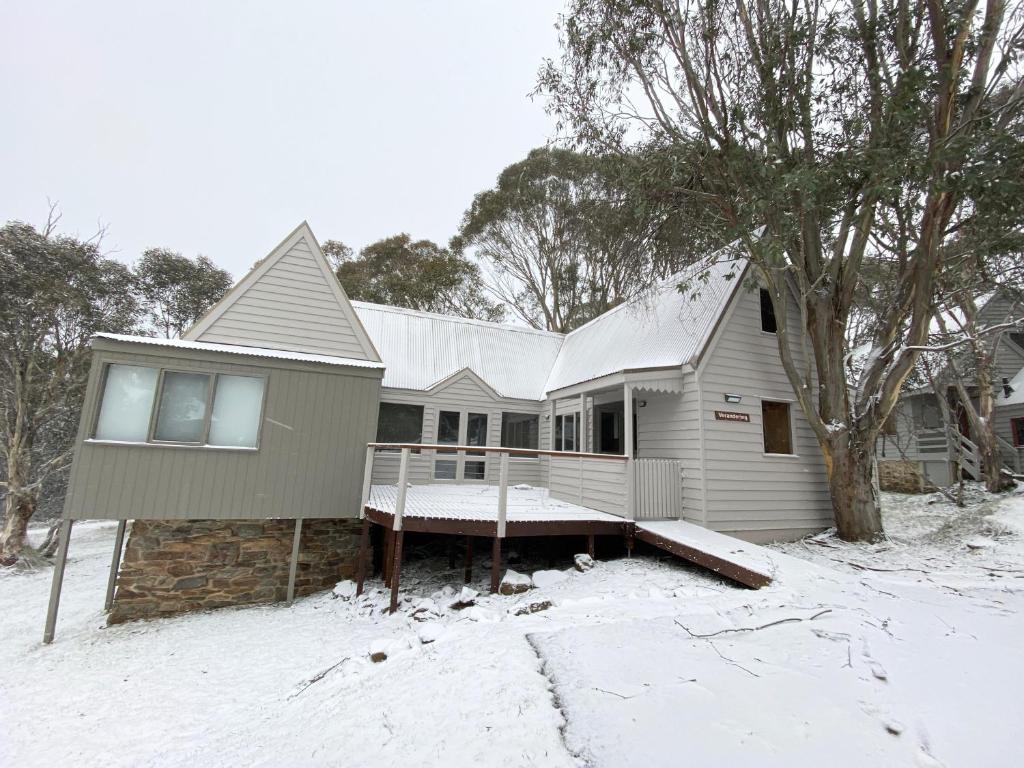 a house with snow on the ground in front of it at Verandering in Dinner Plain