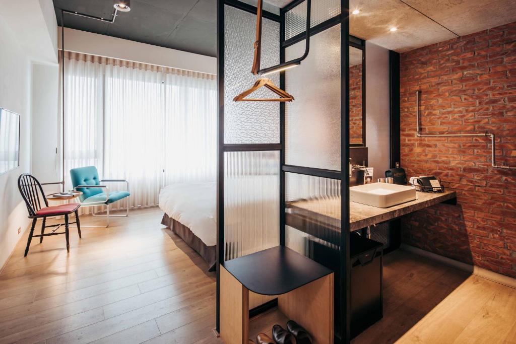 ein Schlafzimmer mit einem Bett und einem Waschbecken in einem Zimmer in der Unterkunft U.I.J Hotel & Hostel in Tainan