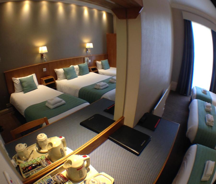 Un pat sau paturi într-o cameră la Columbus Hotel