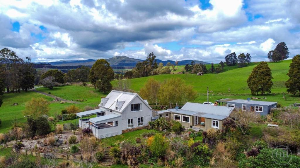 an aerial view of a white house in a green field at The Gardener's Cottage on Warrentinna in Branxholm