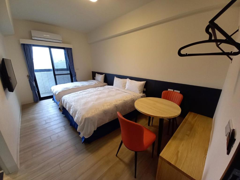 Huxiにある航空棧輕旅民宿のベッド、テーブル、椅子が備わるホテルルームです。