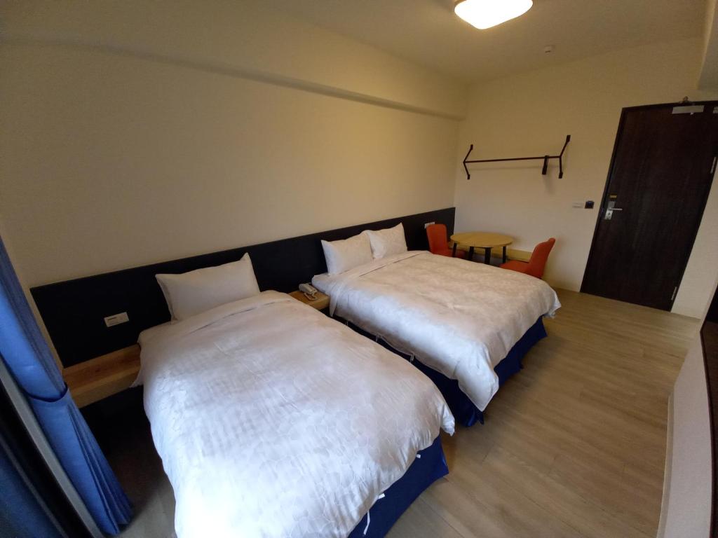 Postel nebo postele na pokoji v ubytování 航空棧輕旅民宿
