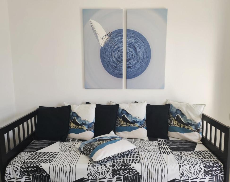 un letto bianco e nero con cuscini in una stanza di ONAR STUDIOS MILOS ad Adámas