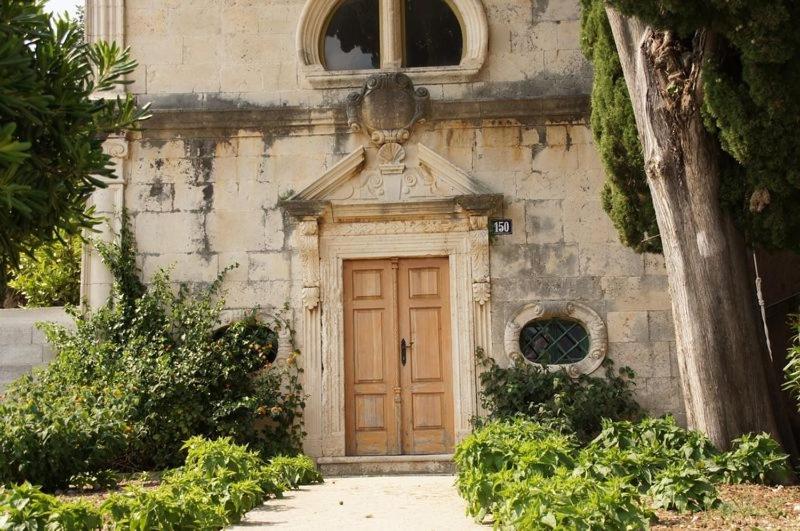 een gebouw met een houten deur ervoor bij Apartments Viganj (22) in Viganj