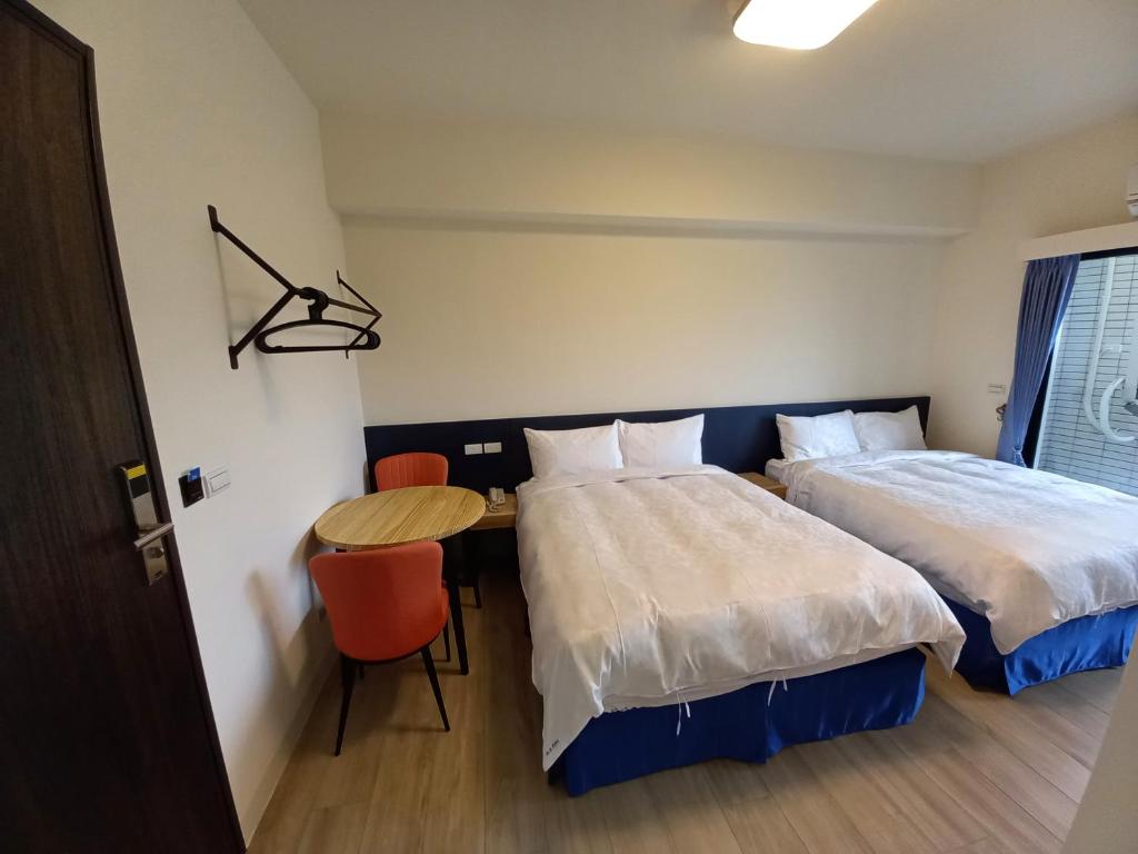 Postel nebo postele na pokoji v ubytování 航空棧輕旅民宿