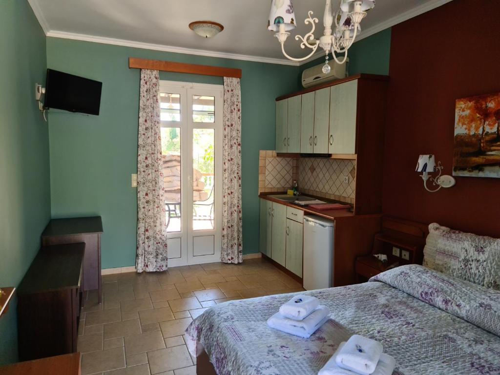 a bedroom with two beds and a kitchen with a window at Edem Studios in Syvota