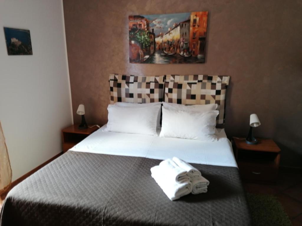 una camera d'albergo con un letto e un asciugamano sopra di A due passi dal mare a Capo dʼOrlando