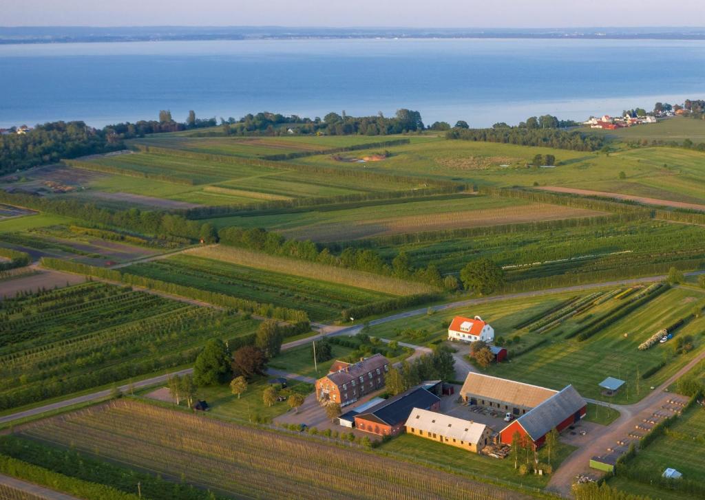 an aerial view of a farm and the water at Bläsinge Gård Kullabygden in Jonstorp