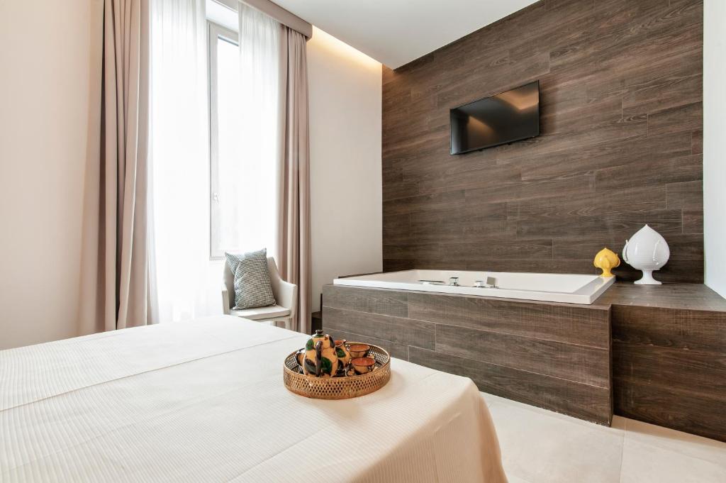 Palazzo San Lazzaro - Jacuzzi Rooms & Suites SIT في ليتشي: حمام به سرير وحوض استحمام ومغسلة