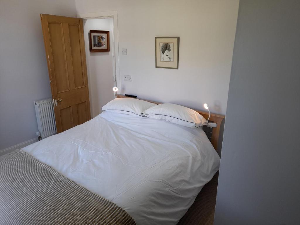 a bedroom with a white bed with lights on it at Burntisland Garden Apartment, Fife - 40 mins to Edinburgh in Burntisland