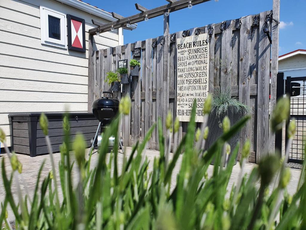 a fence with a sign in front of a house at Olmenduin No. 49 in Serooskerke