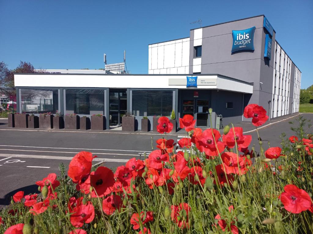 um ramo de flores vermelhas em frente a um edifício em ibis budget Reims Parc Des Expositions em Reims