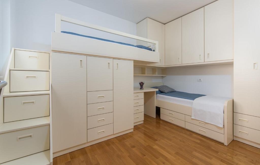 um pequeno quarto com armários brancos e uma cama em Apartment Melarnian near the Beach in Umag em Umag