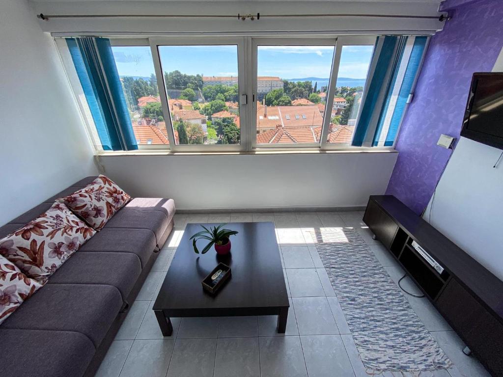 ein Wohnzimmer mit einem Sofa und einem Tisch vor einem Fenster in der Unterkunft Apartments Bella Vista Split in Split