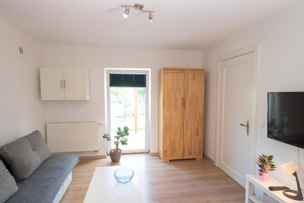 a living room with a couch and a tv at FeWo Engler Lüneburg Hopfengarten in Lüneburg