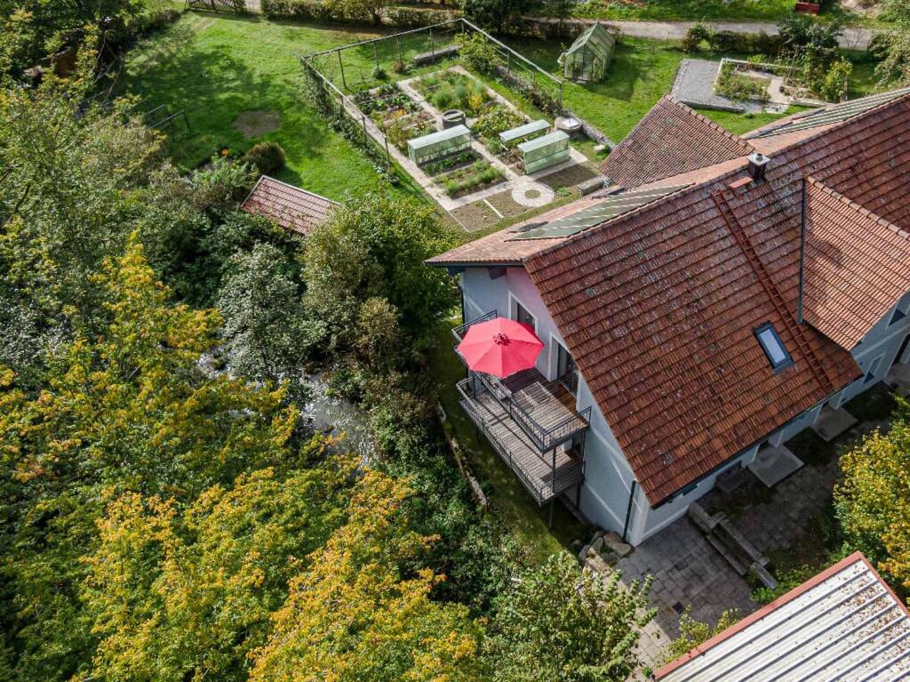 een uitzicht op een huis met een rode paraplu bij Forsthaus Heilsberg in Wiesent