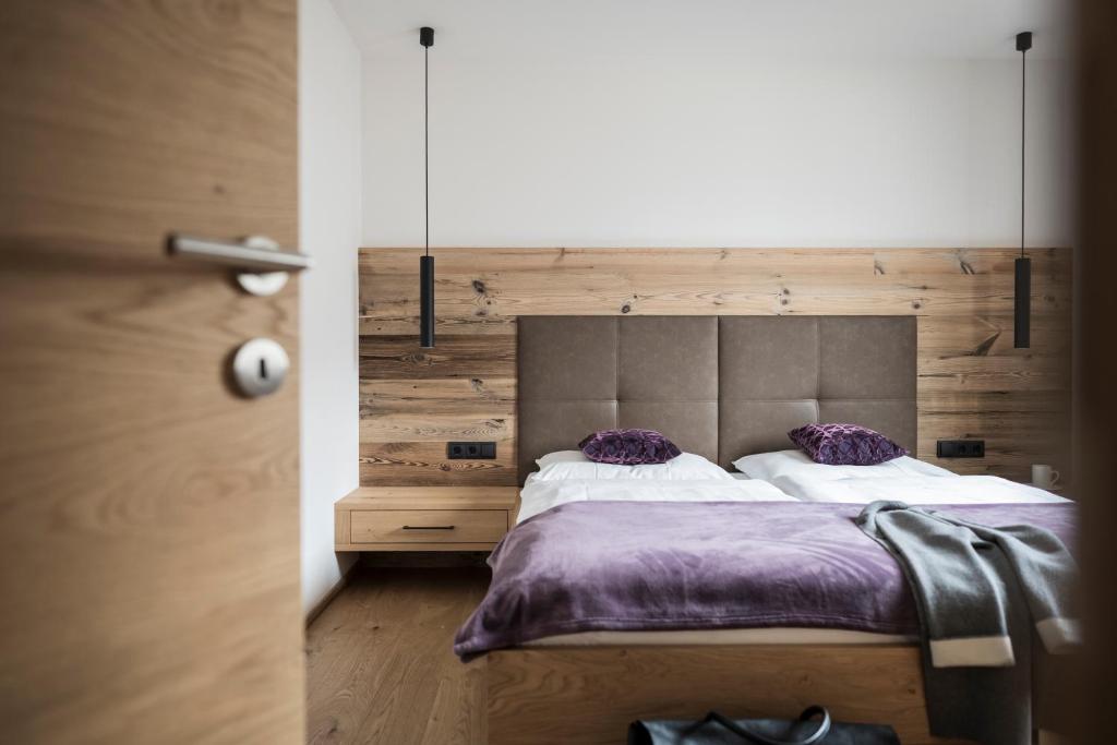 um quarto com uma cama com lençóis e almofadas roxos em Gamz Villa em Sesto