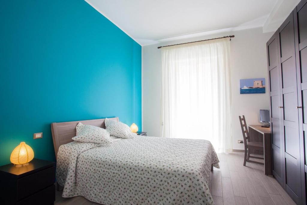 
a bedroom with a white bed and blue walls at B&B Il Sole Blu in Trapani
