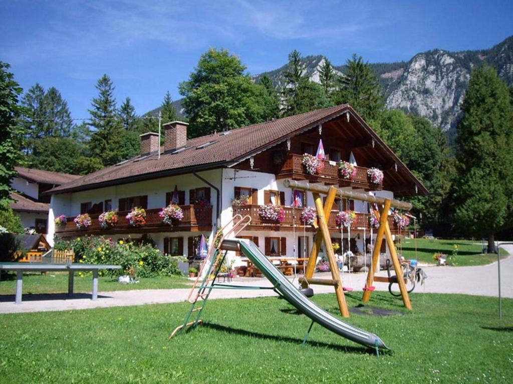 une aire de jeux en face d'un bâtiment avec toboggan dans l'établissement Wiesenhäusl, à Bischofswiesen