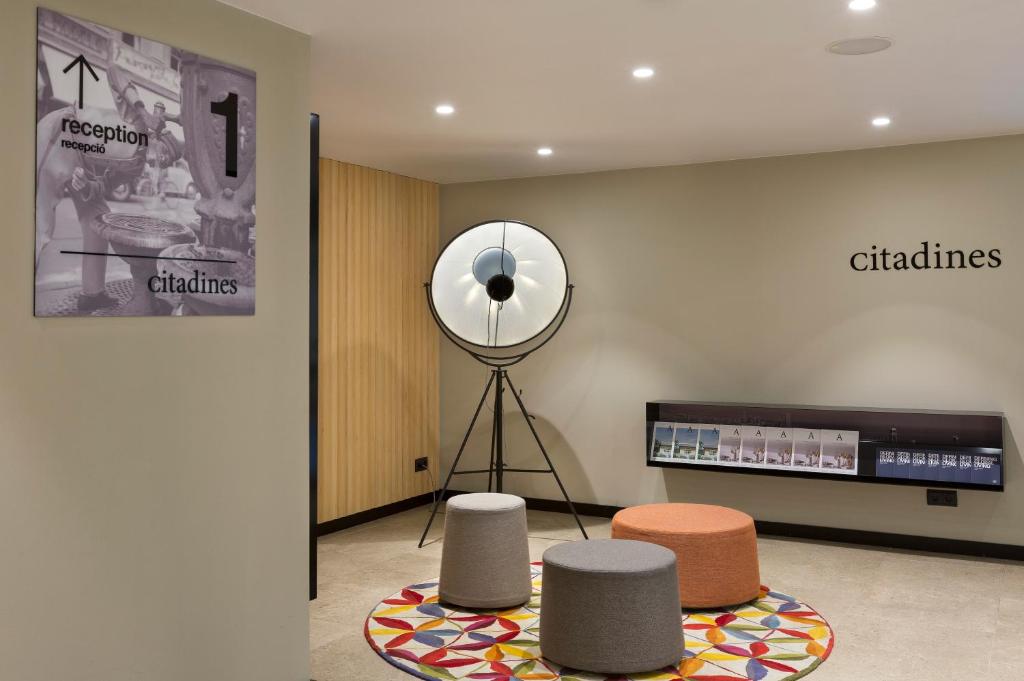 a room with three stools and a mirror on a wall at Citadines Ramblas Barcelona in Barcelona